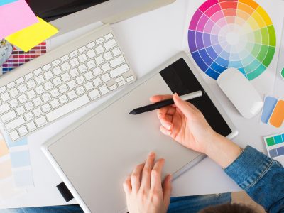 Young pretty Graphic designer using graphics tablet to do her wo